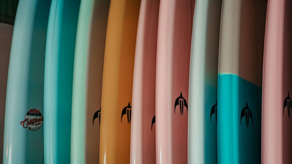 An image of a collection of colourful surfboards