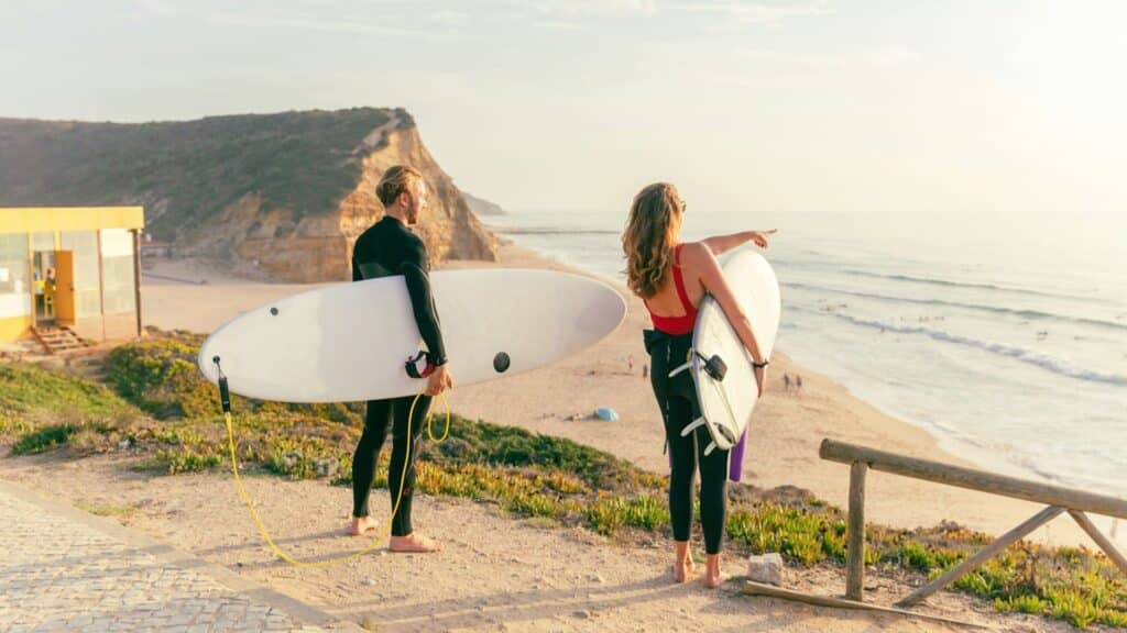 An image of two surfers looking over a beach in Ericeira