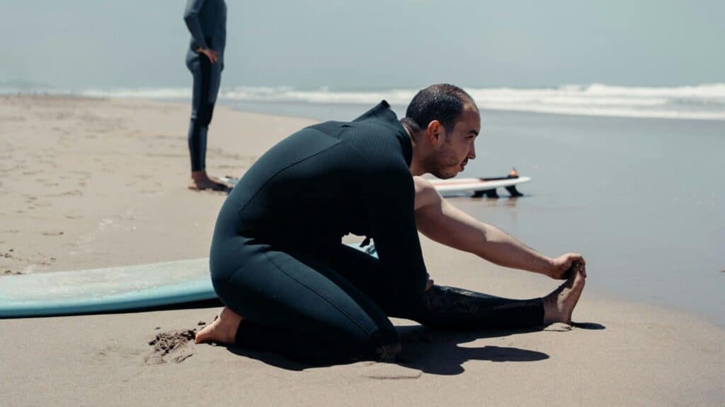 An image of a man stretching in a wetsuit