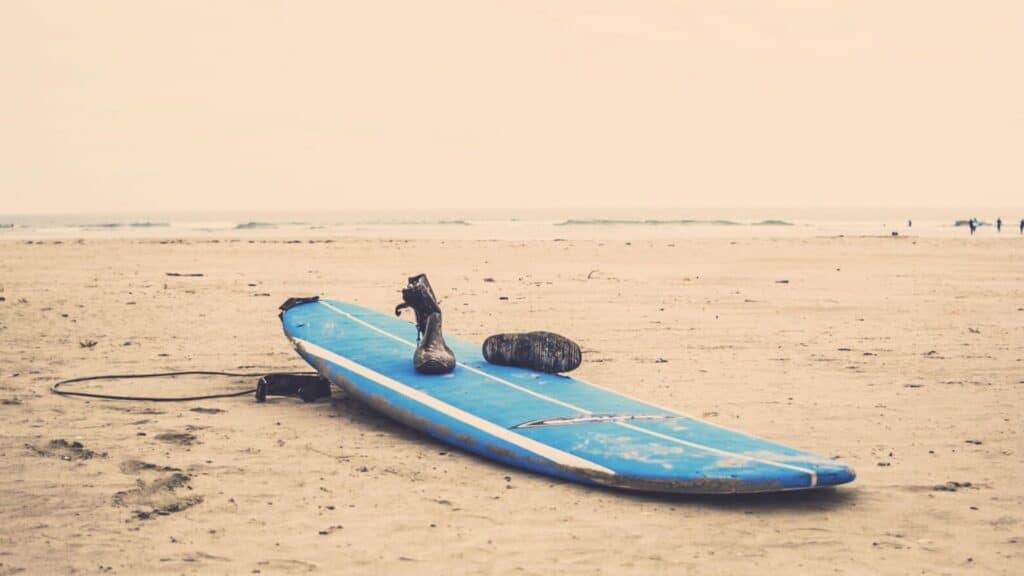 Ein Bild von einem Surfbrett mit Surfschuhen und einer Leash