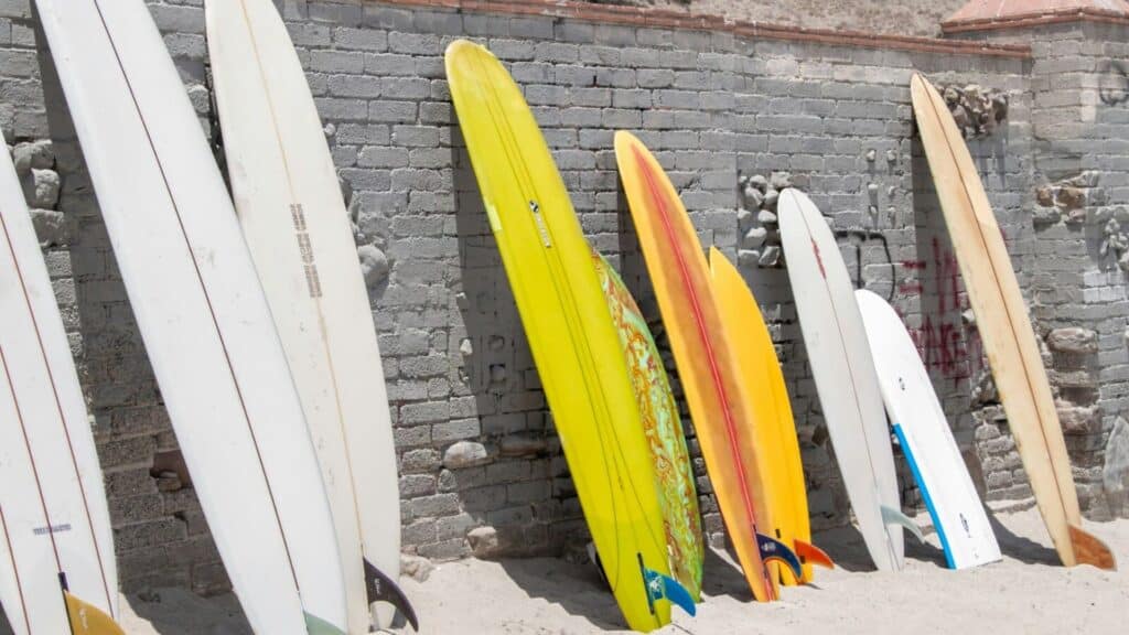 An image of a variety of surfboards resting against a wall