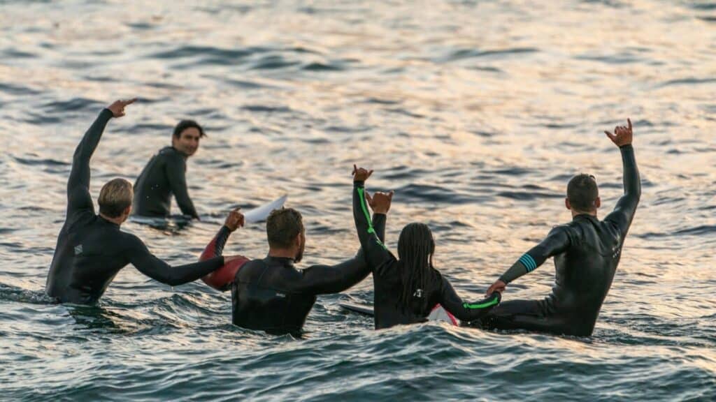 An image of a group of surfers celebrating in the sea
