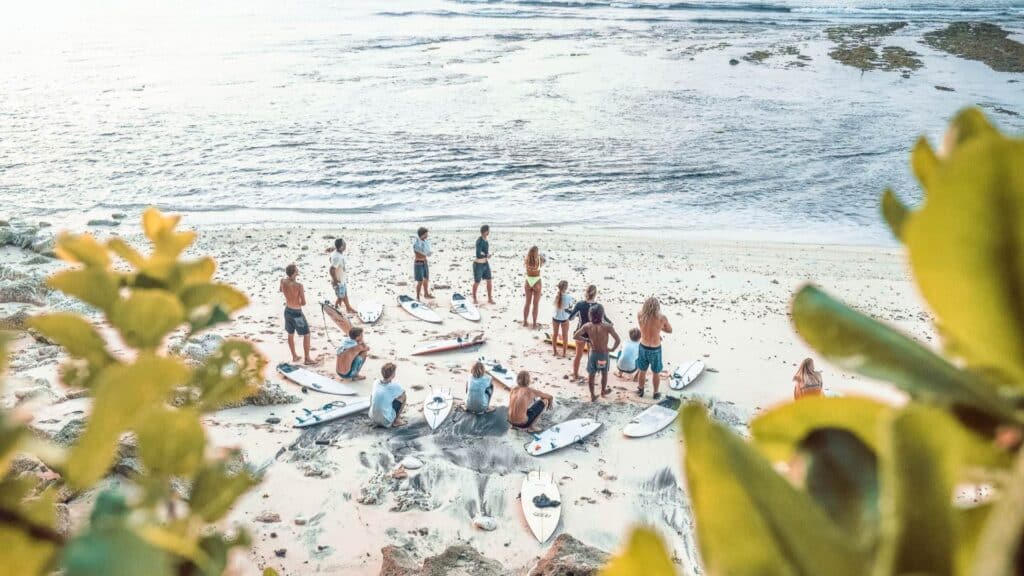 An image of surfers and instructors on a beach in Green Bowl